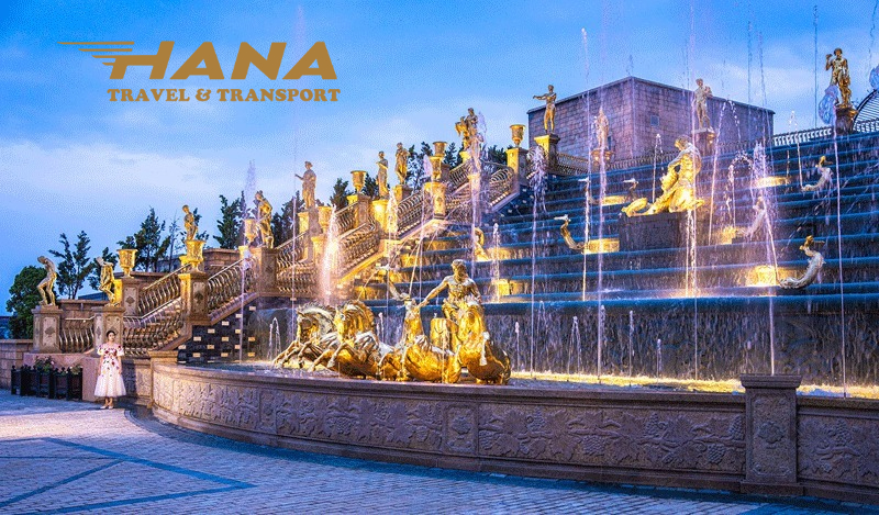 Khung cảnh trung tâm với đài phun nước, du khách check-in, lễ hội Carnival rực rỡ sắc màu.